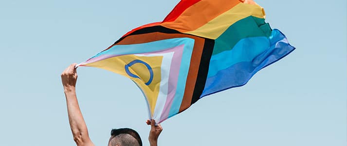 person holding intersex inclusive pride flag