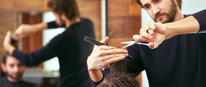 a man getting a haircut at the barbers